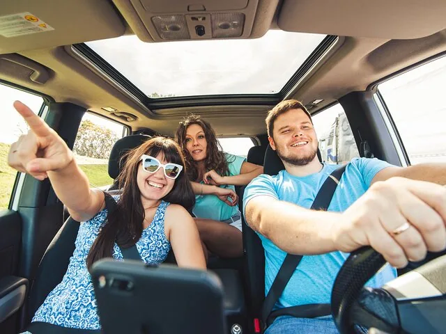 Trois amis s’amusant lors d’un road trip en voiture