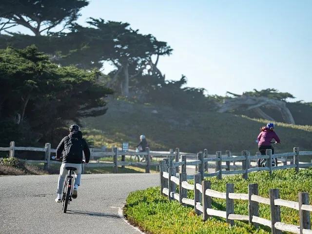 Personnes à vélo le long d’un chemin bordant un parcours de golf